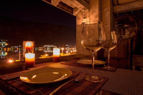 a table with two glasses of wine and candles on it at Kotor old town Palace Bucha in Kotor