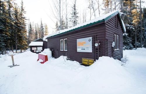 une petite cabine dans la neige avec une bouche de feu rouge dans l'établissement HI Maligne Canyon - Hostel, à Jasper