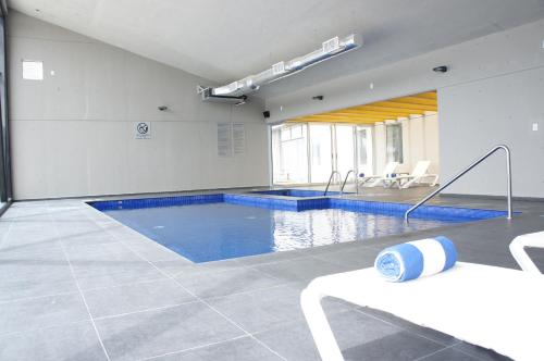 a large swimming pool with blue water in a building at La Quinta by Wyndham San Jose Chiapa Puebla in San José Chiapa