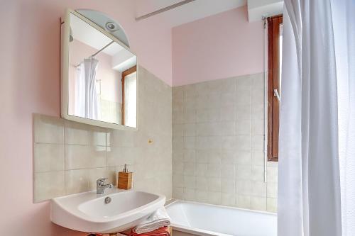 La salle de bains est pourvue d'un lavabo, d'une baignoire et d'un miroir. dans l'établissement Le République, à Châlons-en-Champagne