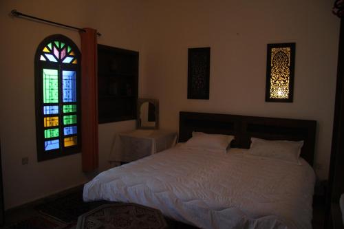 a bedroom with a bed and a stained glass window at dar wassim el ghali in Rabat
