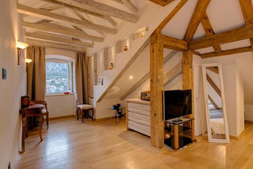 a living room with wooden ceilings and a tv at Kotor old town Palace Bucha in Kotor