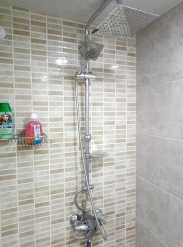 a shower in a bathroom with a tile wall at Old Tbilisi Narikala Apartment in Tbilisi City