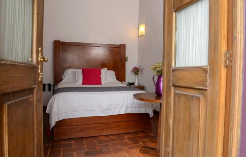a bedroom with a bed and a dresser at El Serafin Hotel Boutique in Querétaro