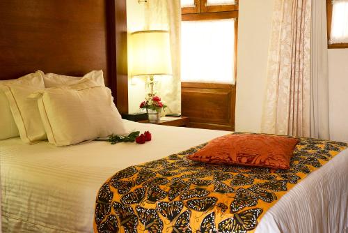 a bedroom with a large bed with a pillow on it at El Serafin Hotel Boutique in Querétaro