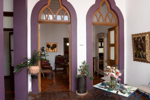 a hallway with purple and white walls and a table with flowers at El Serafin Hotel Boutique in Querétaro