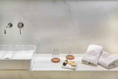 a bathroom with a sink and towels on a counter at Pyrgos Hotel in Ouranoupoli
