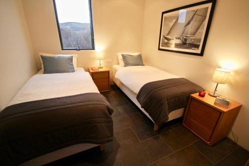 dwa łóżka w małym pokoju z dwoma lampami w obiekcie Nes w mieście Bifrost
