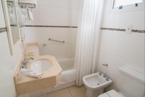 a white bathroom with a sink and a toilet at Gran Hotel Continental in Mar del Plata
