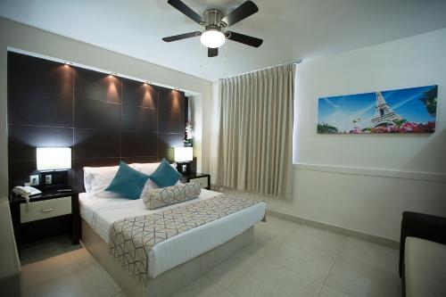 a bedroom with a bed with a ceiling fan and the eiffel tower at Hotel La Torre San Francisco in San Francisco del Rincón