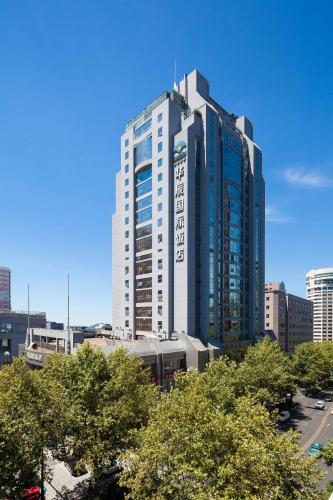 a tall building with a train in a city at Huachen International Hotel in Hangzhou