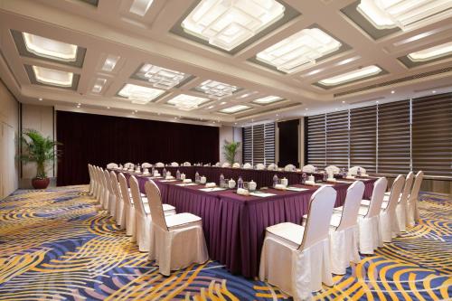 a conference room with a long table and chairs at Huachen International Hotel in Hangzhou