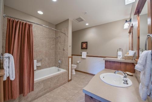 a bathroom with a tub, toilet, sink and shower at Silver Mountain Lodging in Kellogg