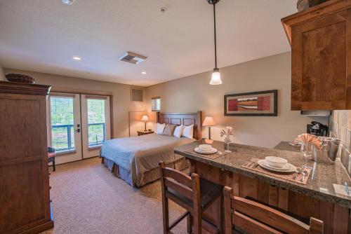a bedroom with a bed and a kitchen with a table at Silver Mountain Lodging in Kellogg