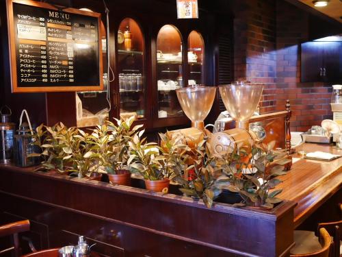 a bar with potted plants on a counter in a restaurant at Hotel Links Dobutsuenmae in Osaka