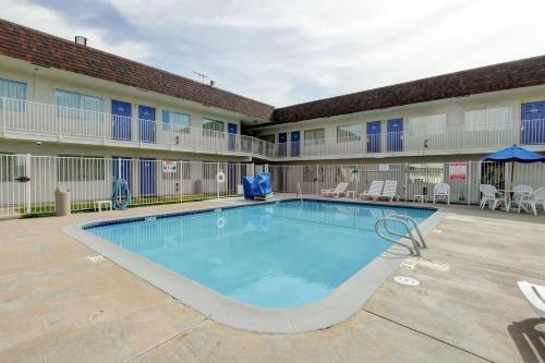 a large swimming pool in front of a building at Motel 6-Denver, CO - Airport in Denver