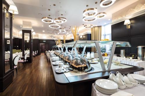 a buffet line in a restaurant with white dishes at The Dostyk Hotel in Almaty