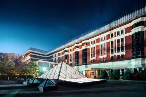 a large building with a sculpture in front of it at The Dostyk Hotel in Almaty