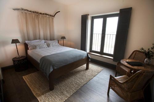 a bedroom with a bed and a window and a chair at The Farmhouse at Meletos in Coldstream