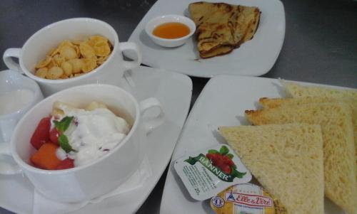 - une table avec deux assiettes de nourriture avec des sandwichs et des sauces dans l'établissement Laguna Gili, à Gili Trawangan