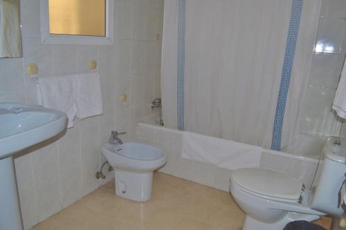 een witte badkamer met een toilet en een wastafel bij Hotel Don Manuel in Algeciras