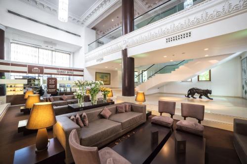 a lobby with couches and a bear statue in the background at The Dostyk Hotel in Almaty