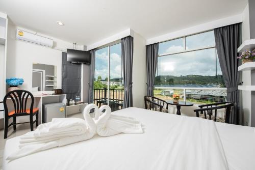 1 dormitorio con 1 cama blanca grande y 2 toallas blancas en Vacation Time House en Nai Yang Beach