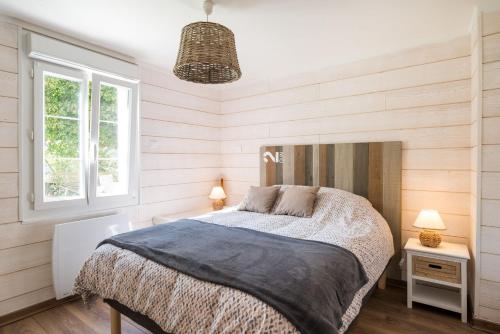 a bedroom with a bed and two lamps and a window at Fleur d'eau in Montperreux