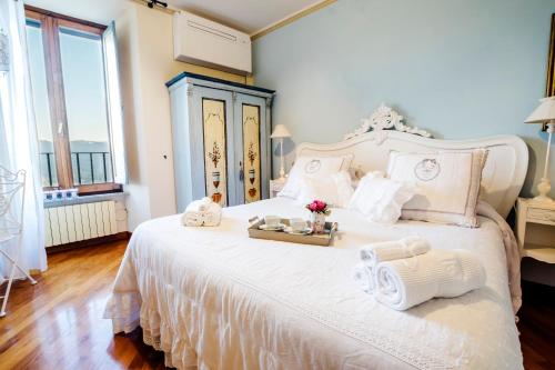 a bedroom with a white bed with towels and flowers on it at Ripa Medici, camere con vista e parcheggio incluso in Orvieto