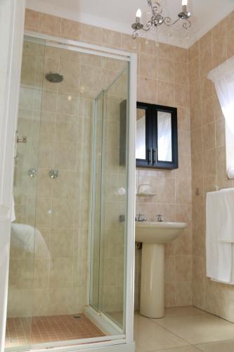 a bathroom with a shower and a sink at Poetry Guestrooms in Vryburg