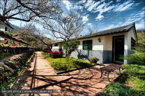 a house with a bench in front of it at Maylin B&B in Xinshe