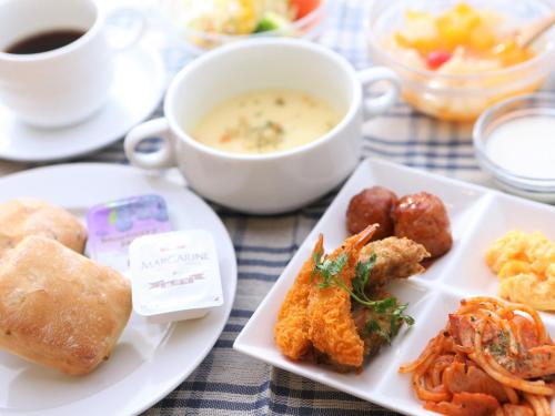 - une table avec deux assiettes de nourriture et une tasse de café dans l'établissement APA Hotel Tottori Ekimae Minami, à Tottori