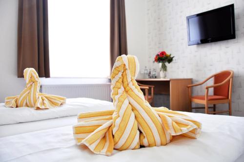 a hotel room with two beds with towels at Hotel Atlantik in Borkum