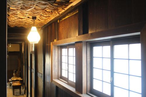 a room with a window and a light fixture at Hostel & Tatami Bar Uchikobare -内子晴れ- in Uchiko