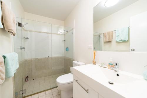 a bathroom with a shower and a toilet and a sink at Joy's Hideaway in Terrigal