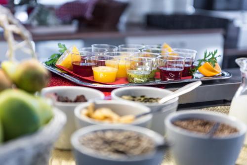 a table topped with cups of food and bowls of fruit at Hotell Solhem Park in Borås