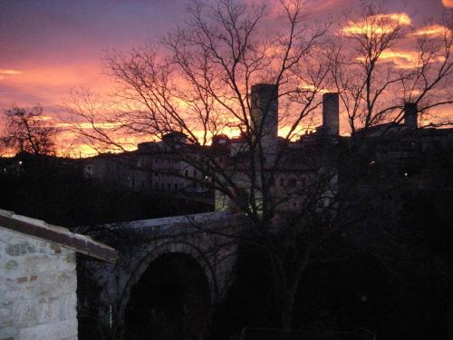 a sunset over a bridge with a building and a tree at Antico Borgo Piceno in Ascoli Piceno