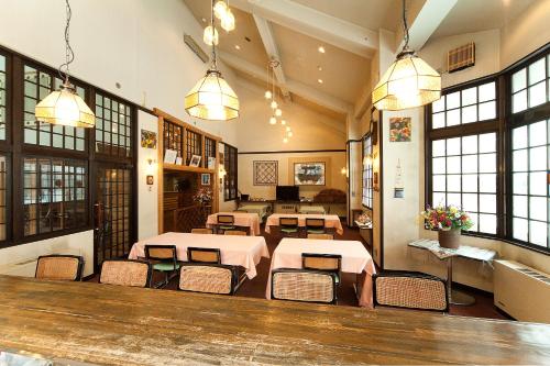 a restaurant with tables and chairs in a room with windows at Hotel Mount Shiga in Yamanouchi