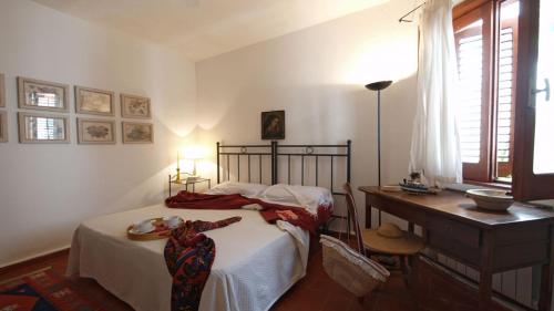 una camera con letto, tavolo e scrivania di Lalli House by DomuSicily a Cefalù