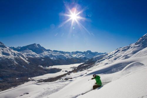 a person is skiing down a snow covered mountain at Boutique Hotel Cervus in St. Moritz
