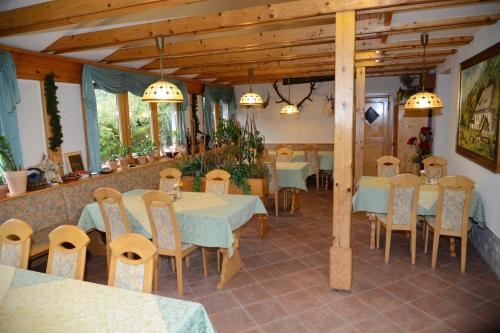 um restaurante com mesas e cadeiras num quarto em Apartmaji Rabič em Bohinj