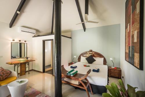 a room with a bed and a table and a couch at Wellesley Resort Fiji in Vunaniu
