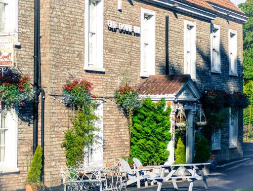 a brick building with benches in front of it at The Old Down Inn in Radstock