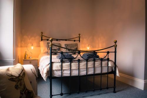 1 dormitorio con 1 cama con marco negro en The Old Down Inn en Radstock