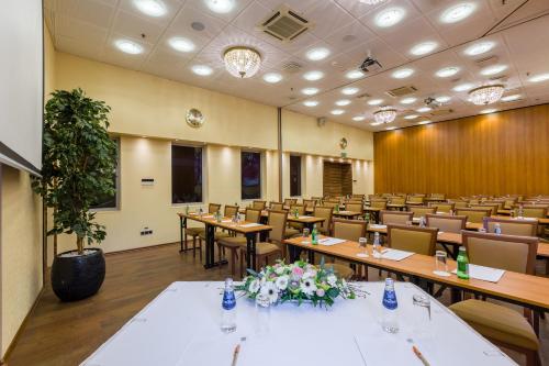 a large room with tables and chairs in a classroom at Avalon Hotel & Conferences in Rīga