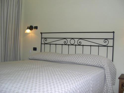 a bedroom with a white bed with a black headboard at Agriturismo la Sforzata in Collegno