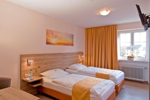 ein Hotelzimmer mit 2 Betten und einem Fenster in der Unterkunft Schützenhof in Neuhof