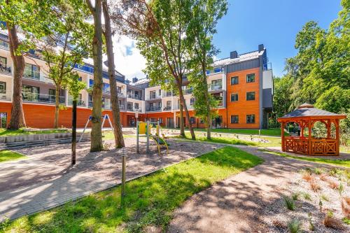 a park with a gazebo in front of a building at Lucky40 - Apartament z widokiem na morze, SPA gratis, Dwie Sosny in Ustronie Morskie