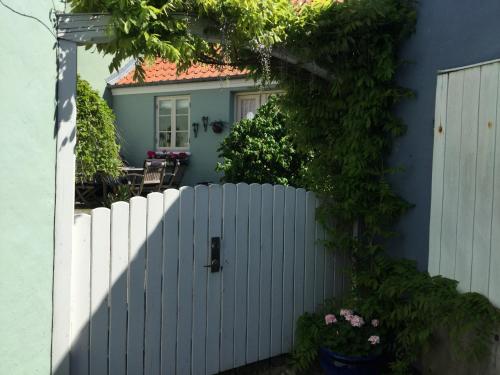 a white fence in front of a blue house at Baghuset in Ebeltoft