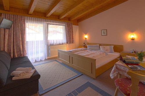 1 dormitorio con 1 cama grande y 1 sofá en Gasthof Pension Granstein en Sölden